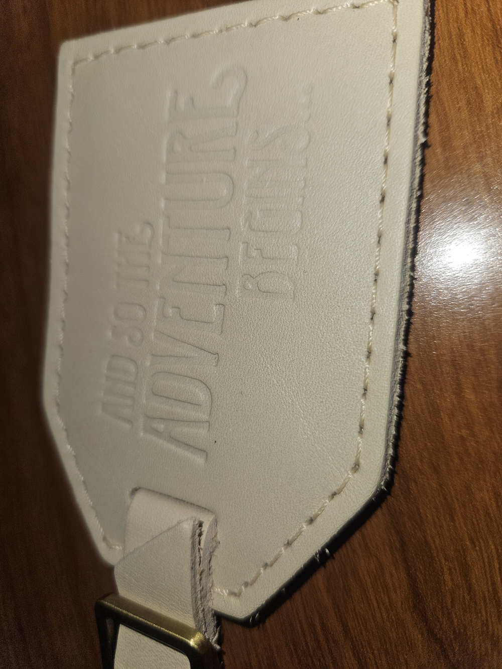 Portland Leather Bone leather luggage tag with embossed "Adventure" detailing.